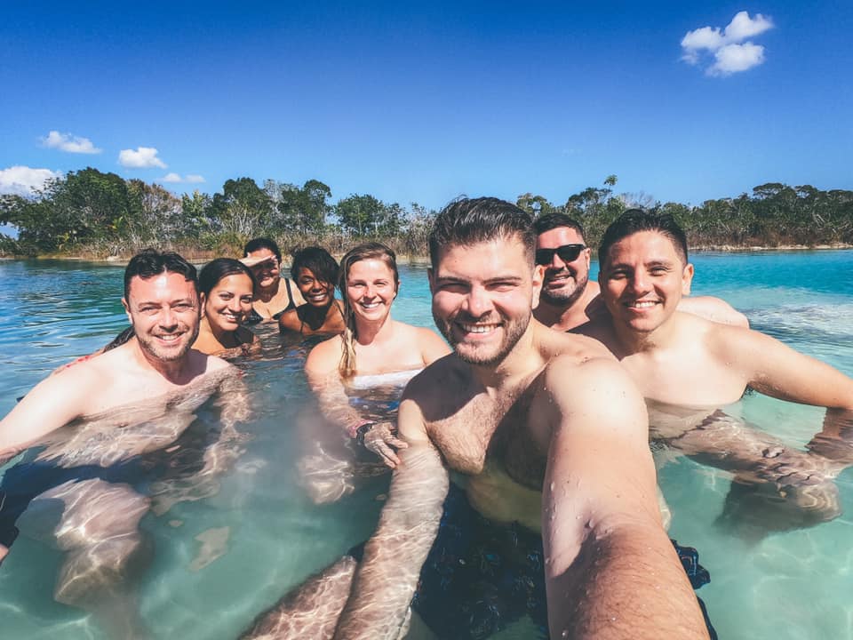 Kate and several of her friends taking a selfie in the clear turquoise water at Bacalar.