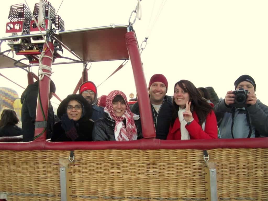 Kate and five other people smiling for the camera in the basket of a hot air balloon.