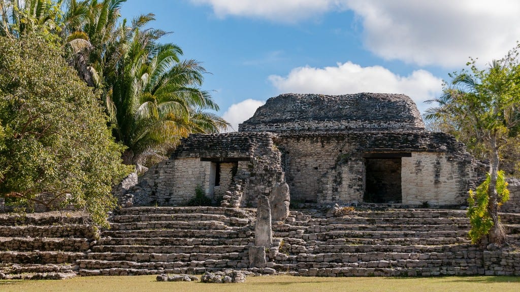 A Mayan ruin that looks like a small stone temple.