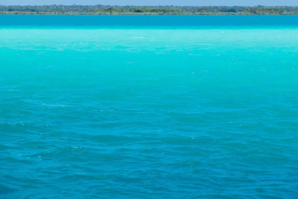 An intensely blue lake, changing different shades of blue as it goes further out.