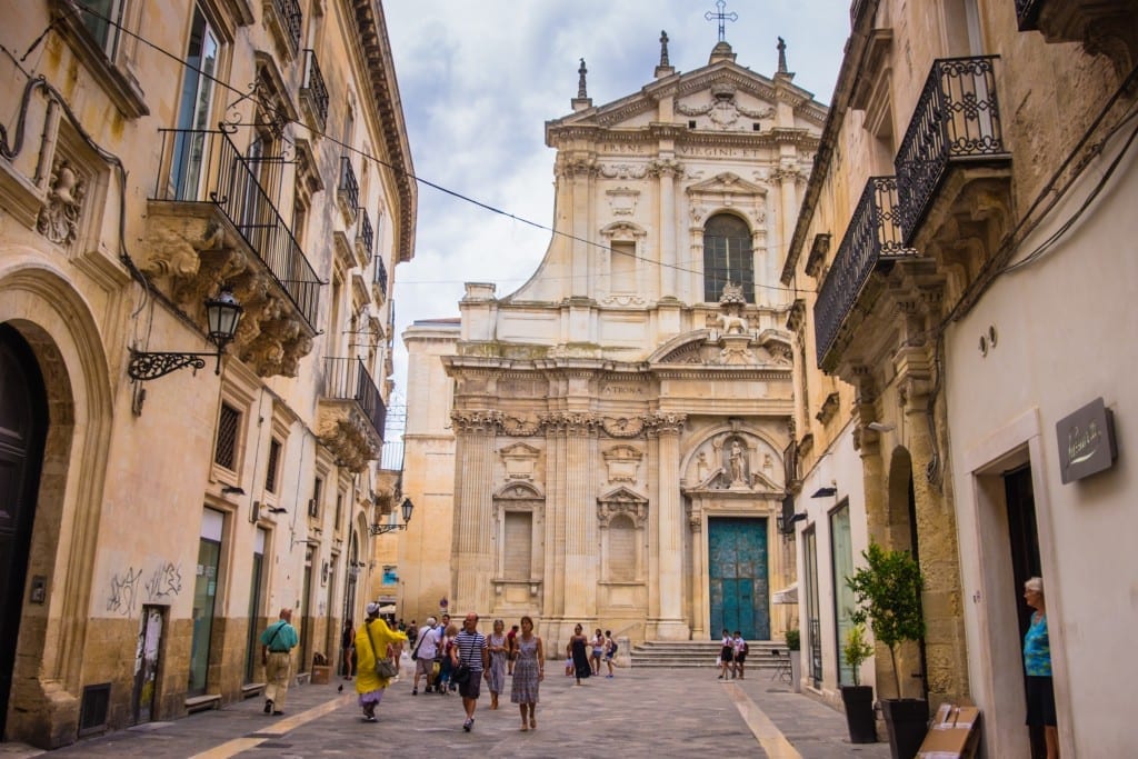 A Baroque cathedral peeking out from an Italian alleyway in Lecce, Italy.