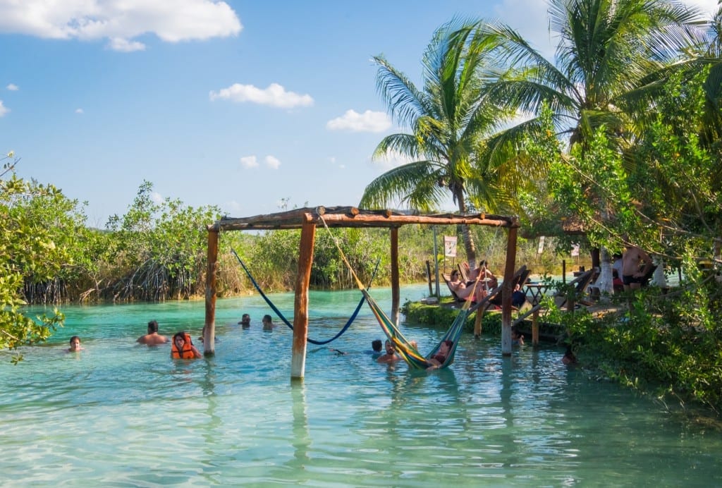 Hammocks in the bright blue water at Los Rapidos, Bacalar