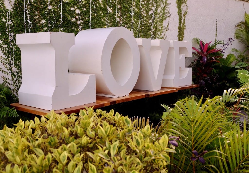 Giant white letters reading LOVE surrounded by greenery in Bacalar.