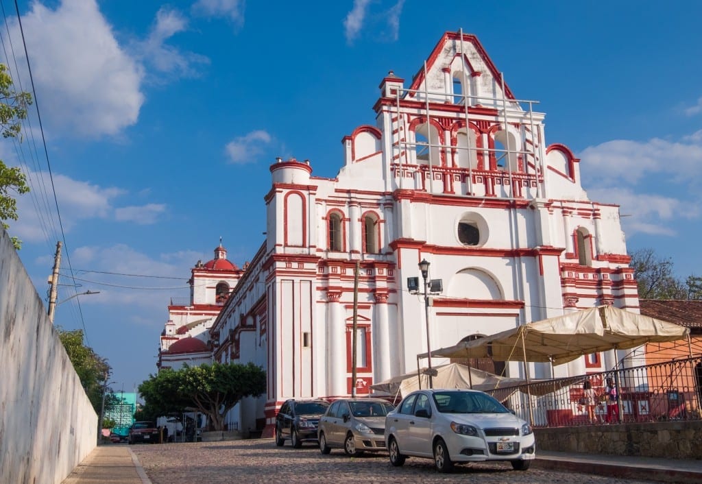 A bright red and white church on a colonial street.