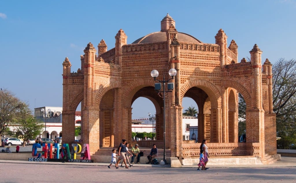 An octagonal red brick structure in the center of a plaza.