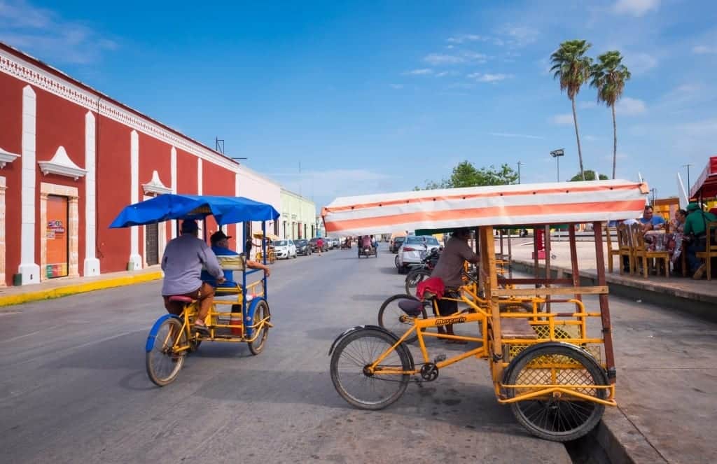 A few men driving bicycle taxis.