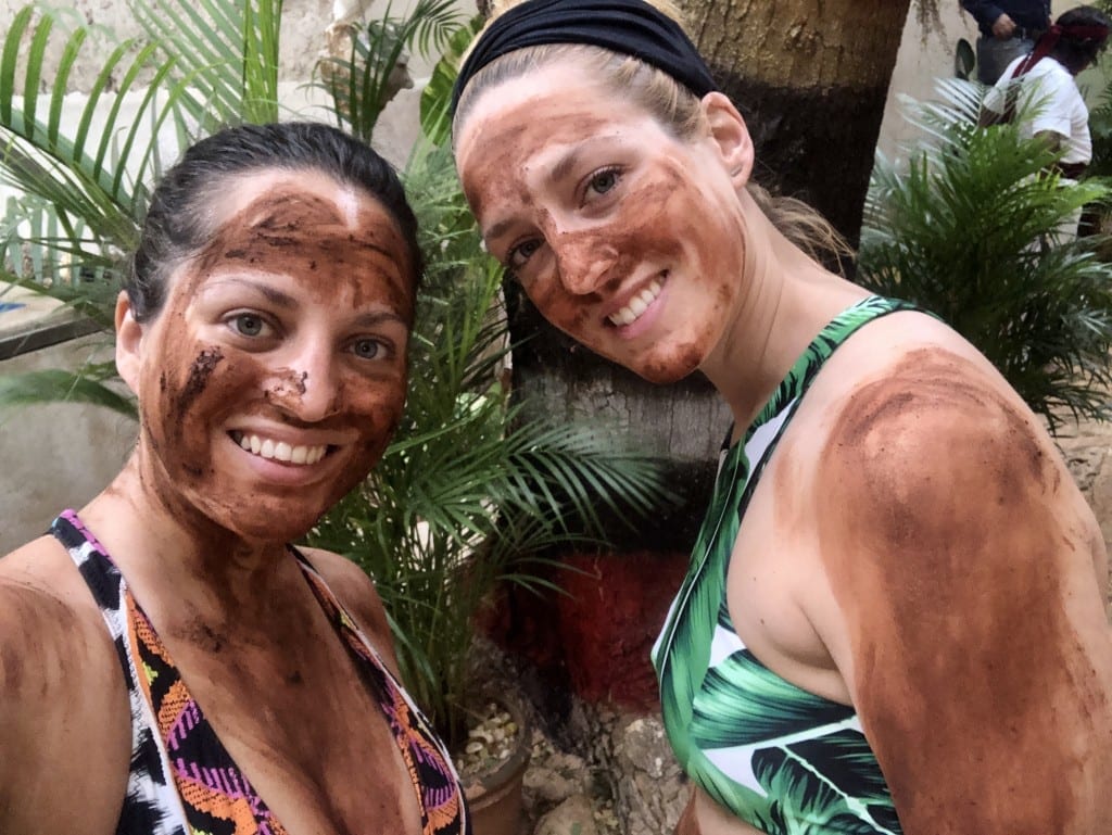 Kate and Sarah covered in dark brown mud for the Mayan healing ceremony.