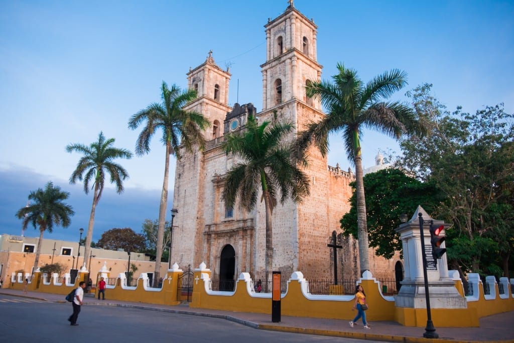 A colonial church in Mexico surrounded by palm trees.