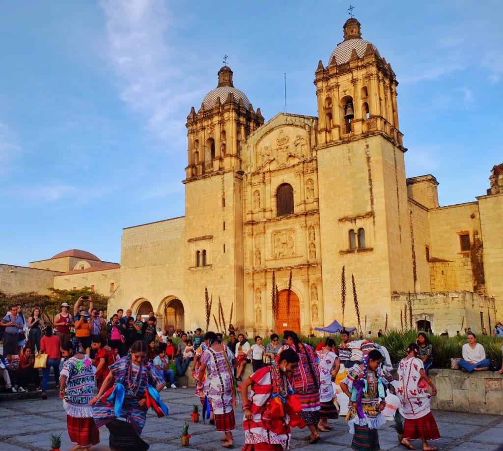Dancers in indigenous clothing in front of a church in Oaxaca.