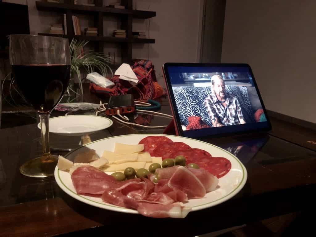 A plate of cured meats and cheeses in front of an iPad with Joe Exotic on it