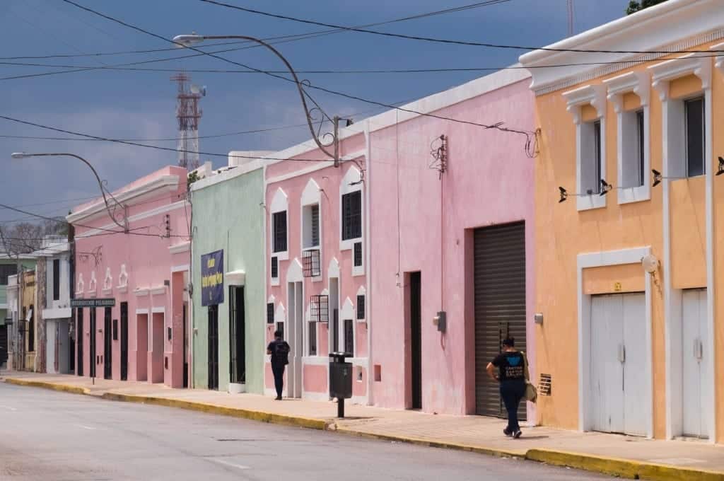 A street with pink, yellow and green homes in Merida, Mexico.