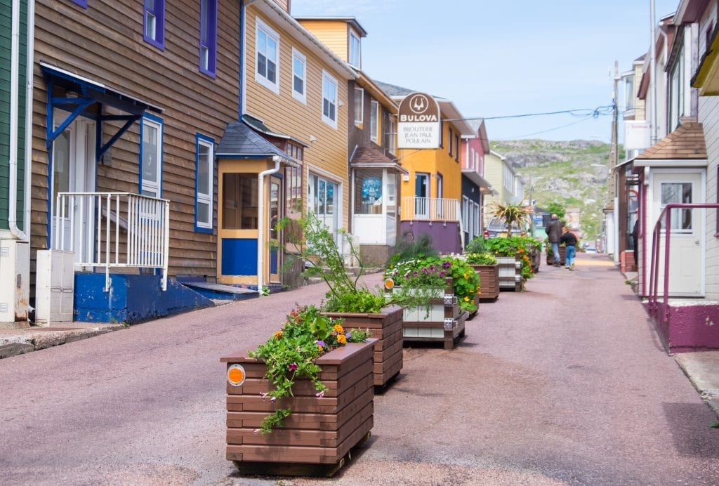 Colorful homes in St. Pierre and a street filled with flower planters.