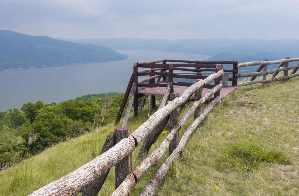 A wooden fence and balcony overlooking the Danube river on a cloudy day.