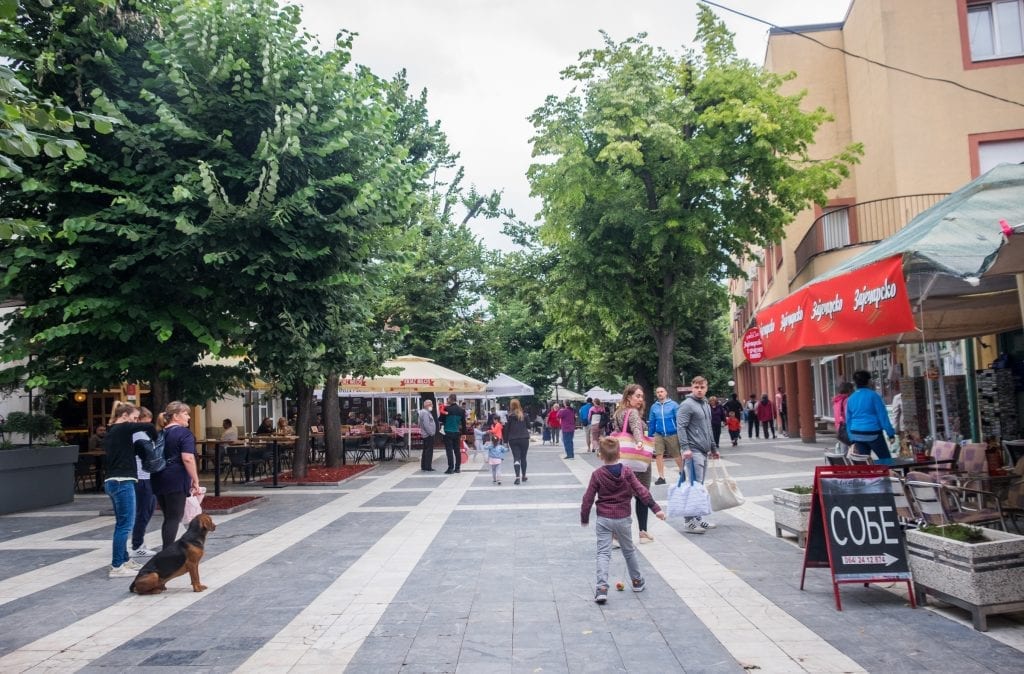 A pedestrian-only street in Sokobanja lined with shops, people walking down the street.