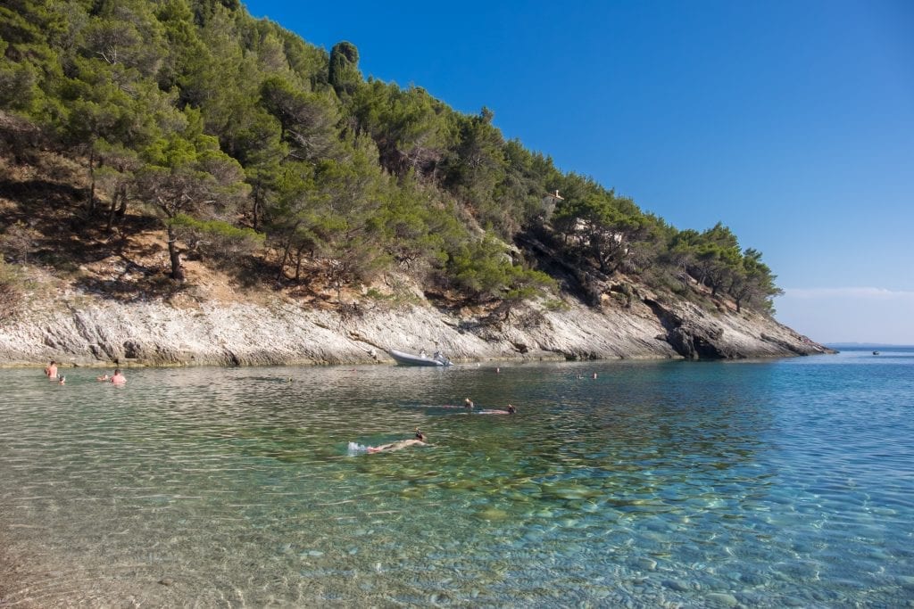 Bačva Beach: a few kids snorkeling in calm, clear blue-green water.
