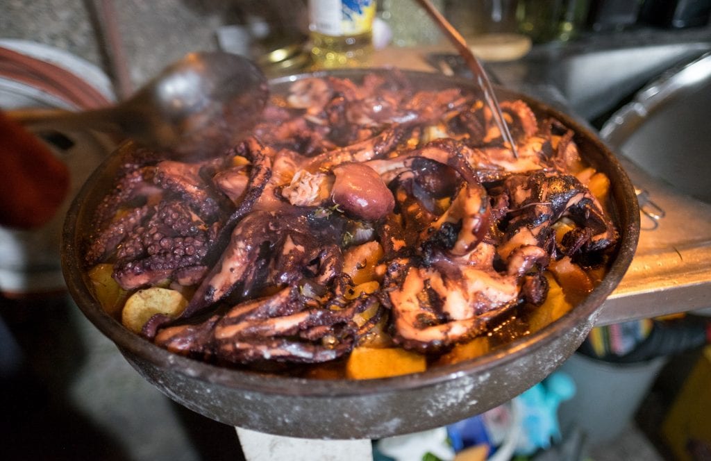 A cast iron pan filled with cooked octopus and potatoes for a peka dinner in Dubrovnik, Croatia.