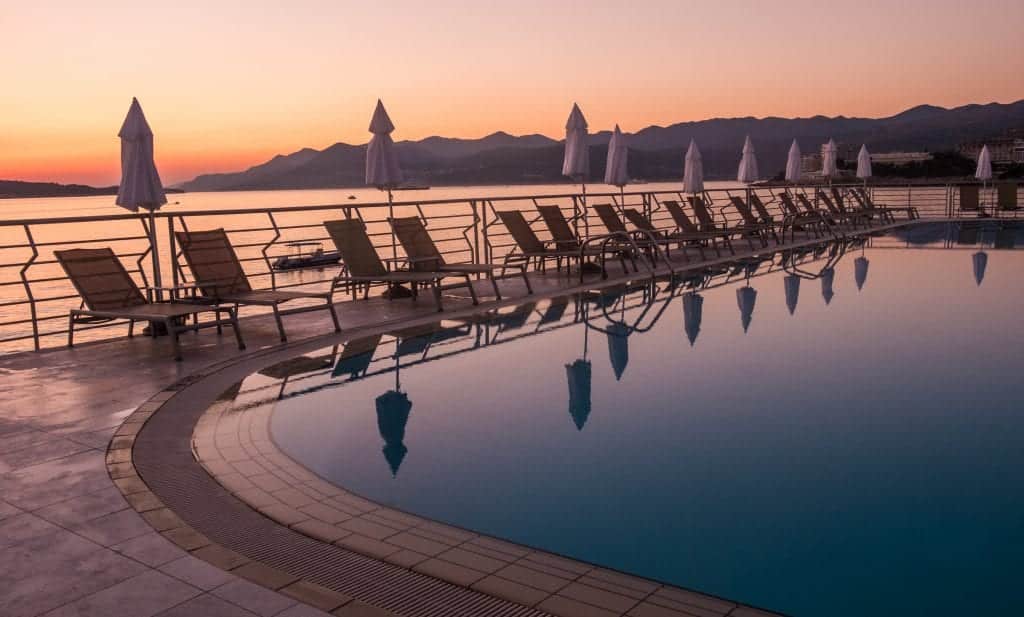 The pool at Hotel Dubrovnik Palace at sunset, lined with beach chairs and umbrellas