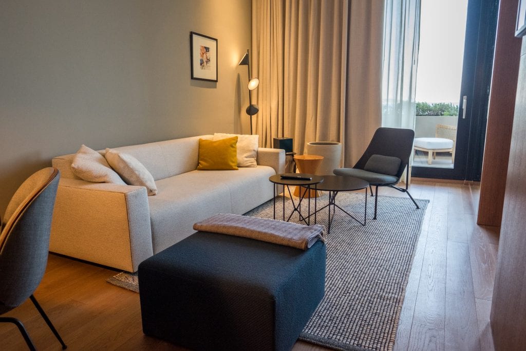 Modern beige couch, grey ottoman and black chair in a seating area inside a room at Hotel Dubrovnik Palace