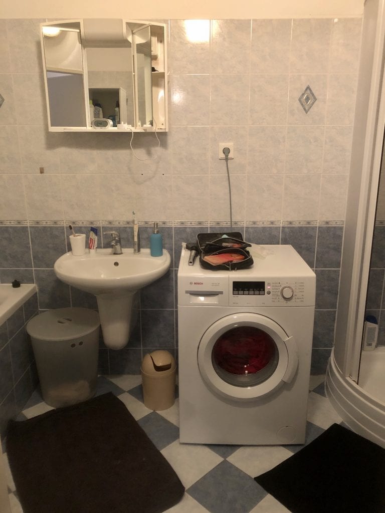 The other bathroom: a sink, very high vanity, and washing machine.