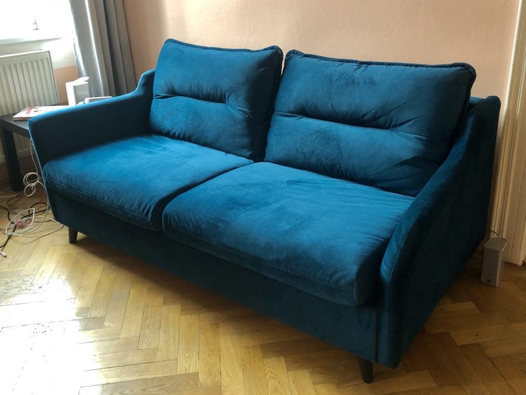 A teal microfiber couch with long rectangular cushions on top. Very modern.
