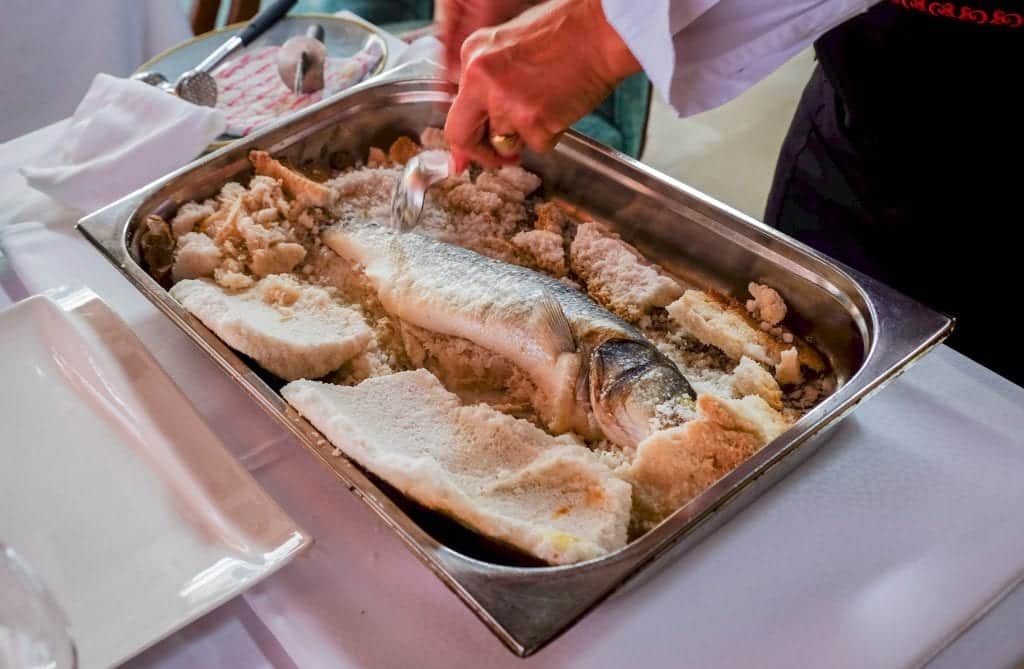 Fish cooked in a crust of sea salt served in a large silver platter