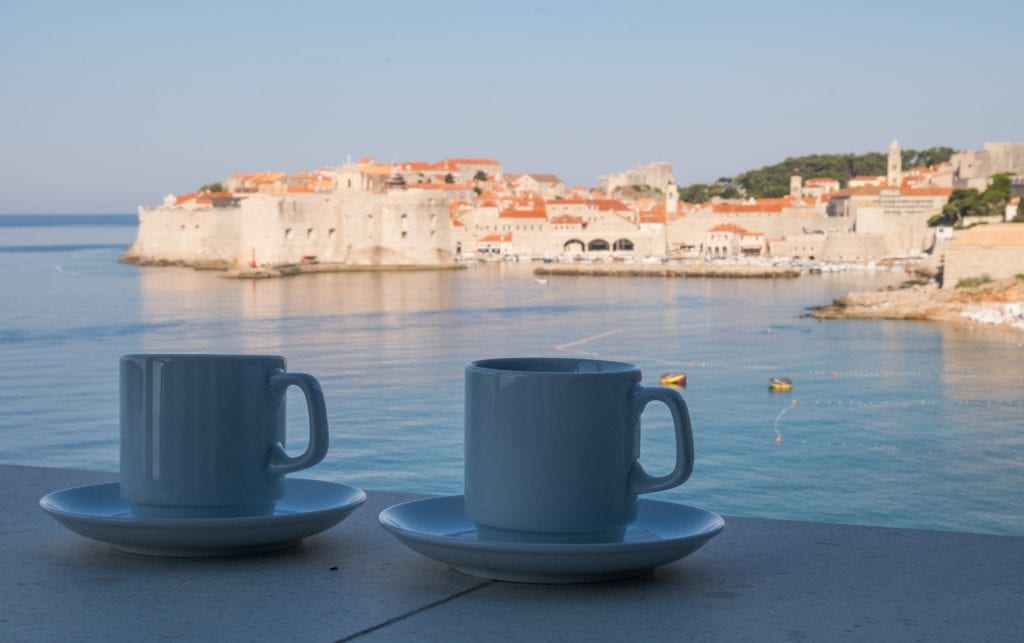 Two coffee mugs on a ledge overlooking the Adriatic Sea and Old Town of Dubrovnik