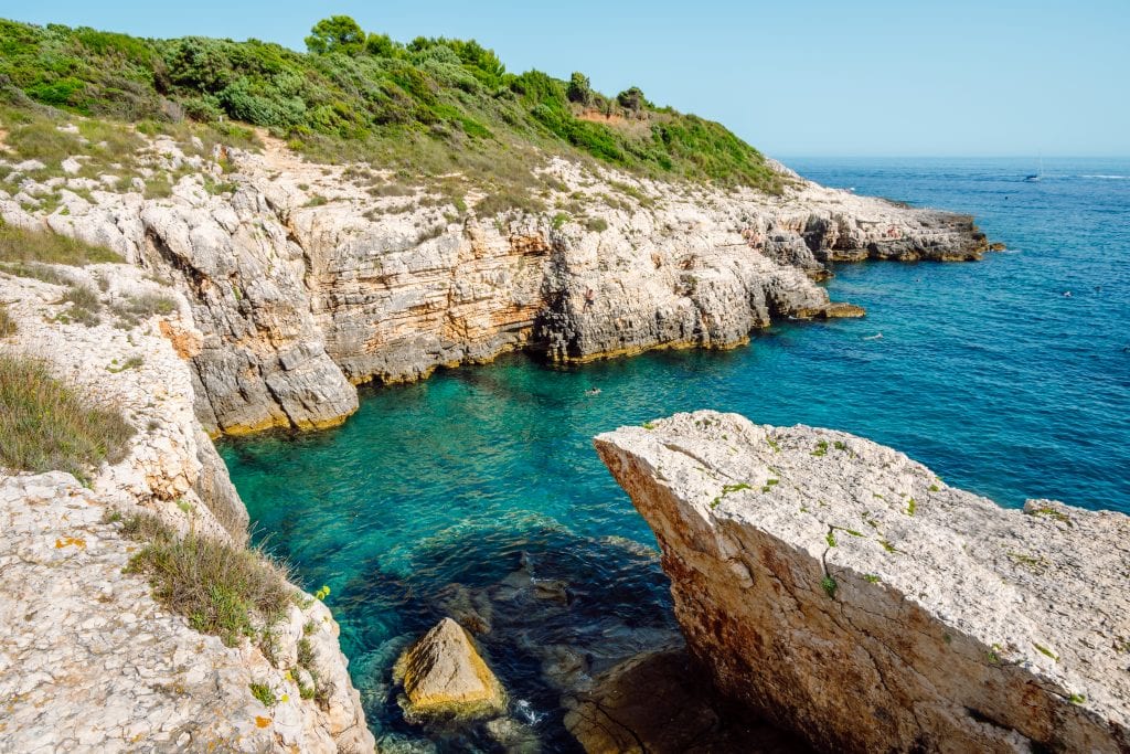 The rock slab beaches of Kamenjak, and cliffs leading down into bright turquoise water.