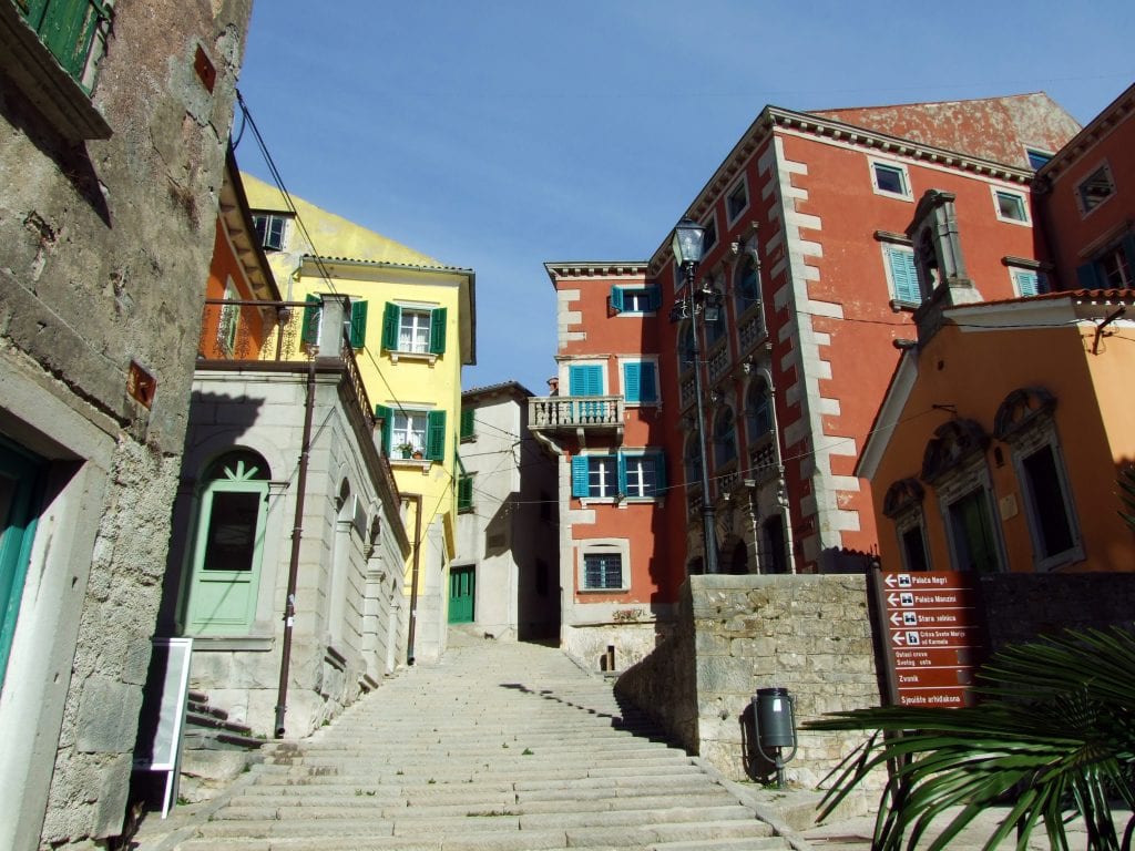 A stone staircase leading up into the pastel colored buildings of the town of Labin, Croatia.