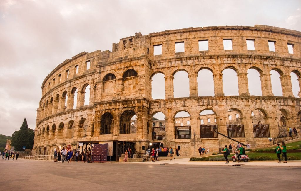 Pula's enormous Roman amphitheater, looking almost the same as in roman times, some people around the edge (including one guy inexplicably on a moped with a Union Jack flag).