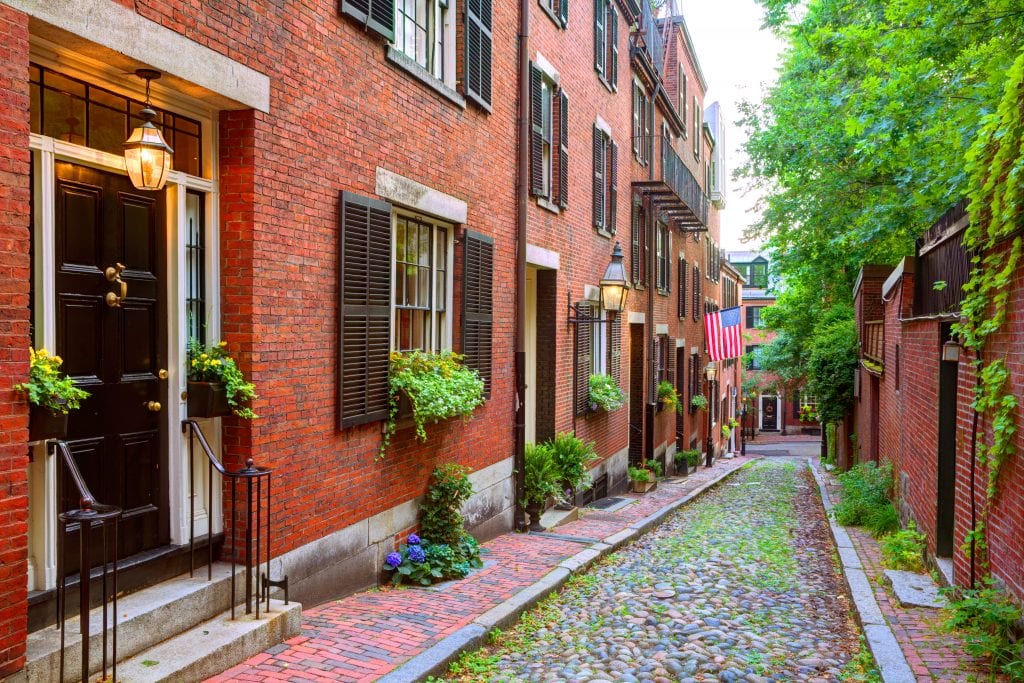 A cobblestone street in front of stately brick homes in Beacon Hill, Boston.