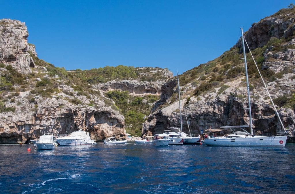 Sailboats waiting outside the narrow entrance between cliffs to Stiniva Bay, Vis