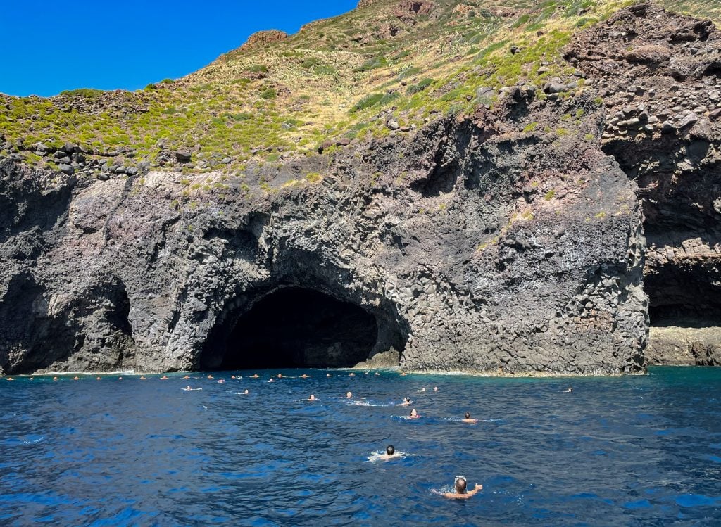 About a dozen people swimming back from a gaping cave on Filicudi.