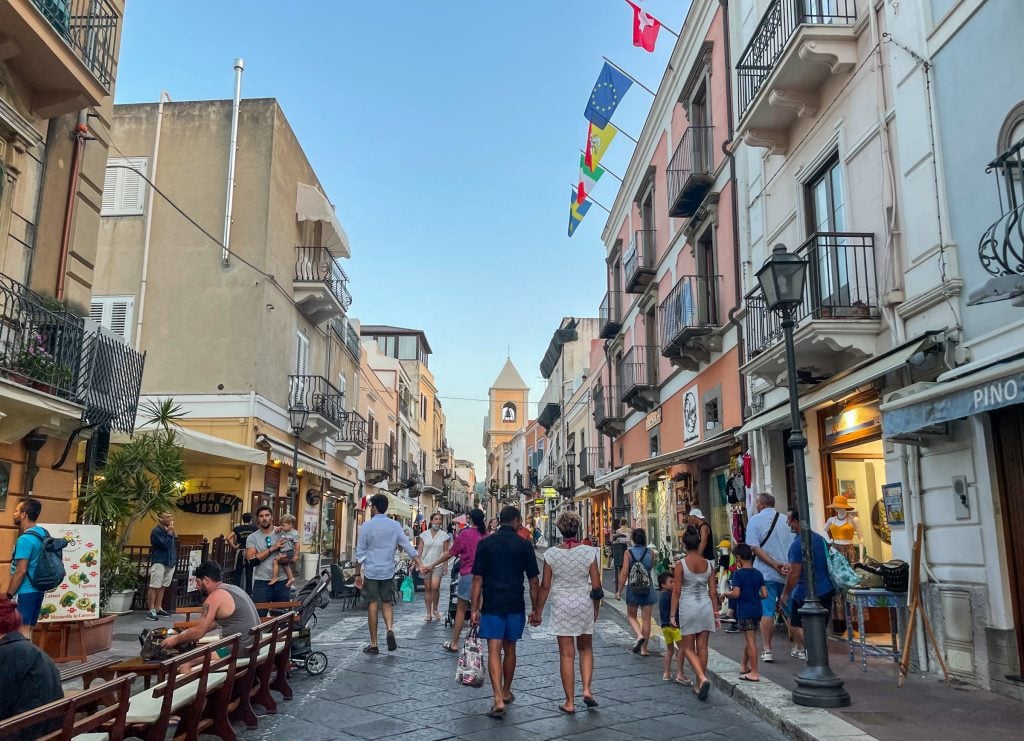 Crowds walking down the shopping street of Lipari, dozens of boutiques on each side.