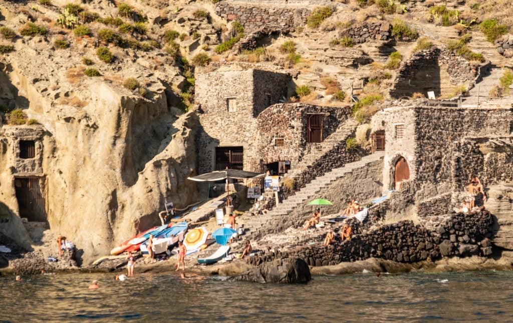 Pollara Beach is more lik e a stone staircase leading to the water, and some driveways leading to doors. It's not really a beach, but people are sitting on the stairs and rocky sides, even putting up umbrellas.