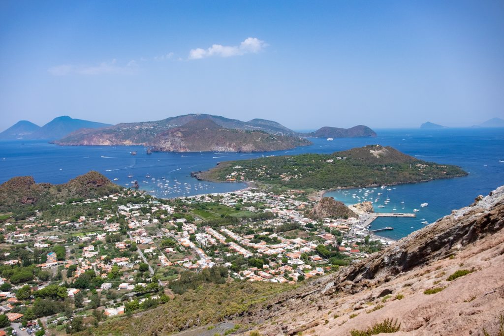 A view over several bright green islands in the Mediterranean from the island of Vulcano.
