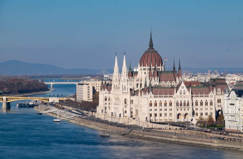 Budapest's spiky Parliament building, set on the bright blue river underneath a blue sky.