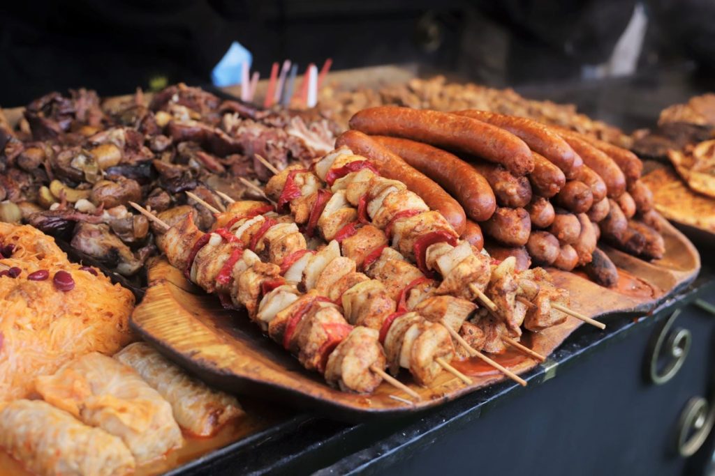 Platters of meat, including shish kebab and sausages.