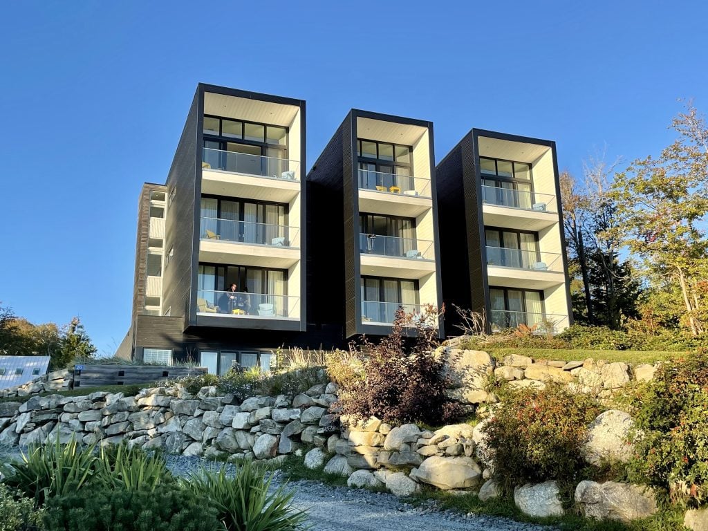 A modern complex: a building that has three columns, each with three balconies (one on top of the other), all facing the ocean.