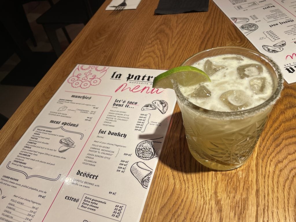 An authentic margarita in a crystal glass next to a menu at a New Mexican restaurant.