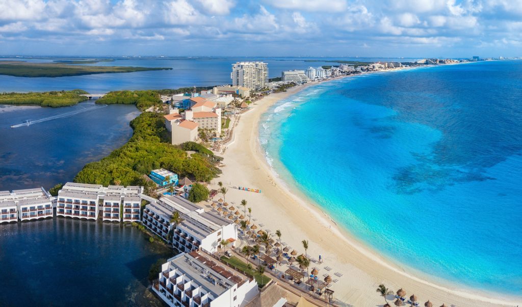 Beach resorts in Cancun, with the turquoise Caribbean Sea and long golden beach on one side, and the lagoon on the other.