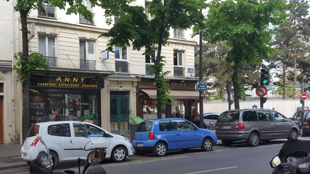 Three cars parked on the street in front of two closed businesses, Anny and Choisy.