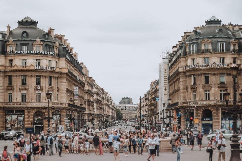  A view down Avenue de l'Opera busy with pedestrians and traffic on a summer day with high clouds. Cloudy weather