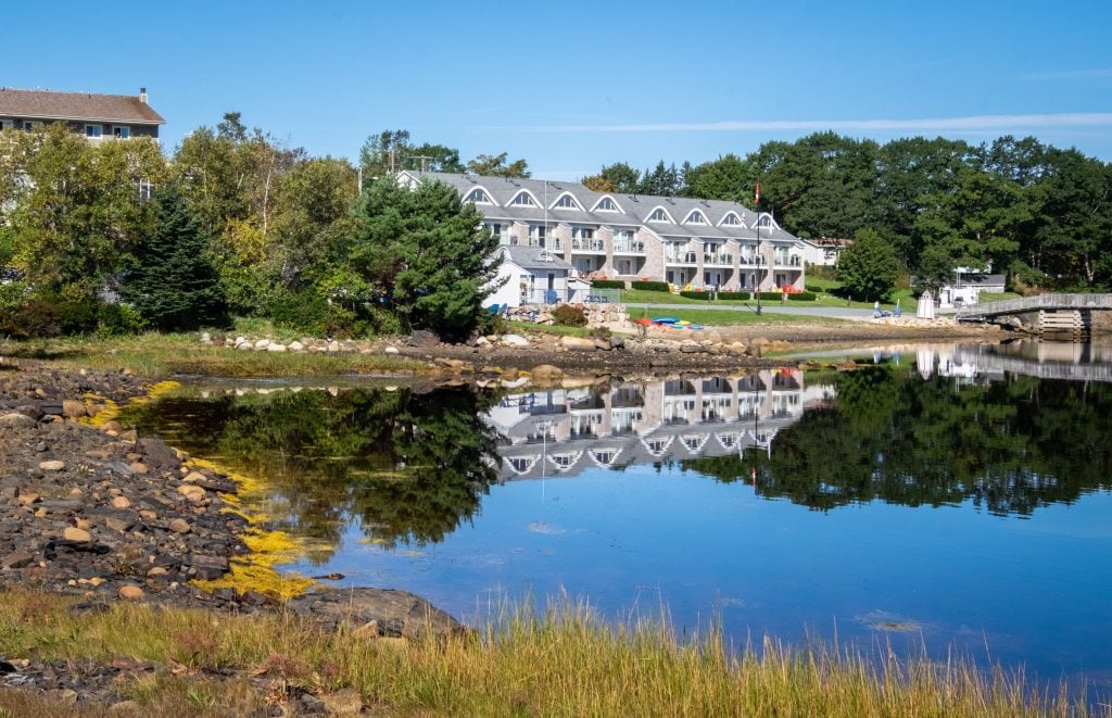 Oak Island's gray rows of hotel rooms reflecting in the blue bay.