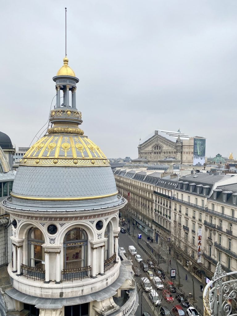 Aerial view of Bouvelard Haussmann in Paris with a beautiful blue and gold dome in the front