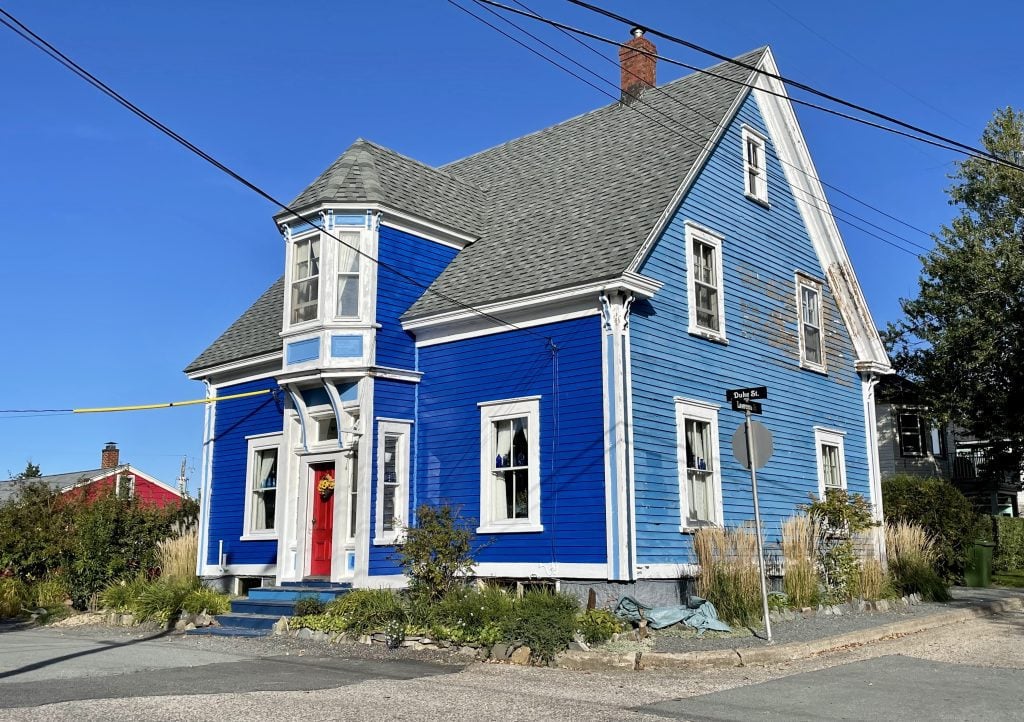 A small blue cottage with a bright red door.