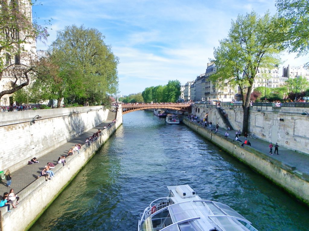 A view from Quai de Montebello 5th arrondissement of a riverboat passing down the Seine River
