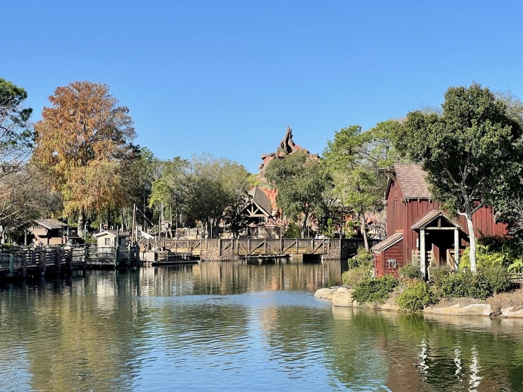 Tom Sawyer Island, with cottages along a river, and you can barely see the desert dome of Thunder Mountain behind it.