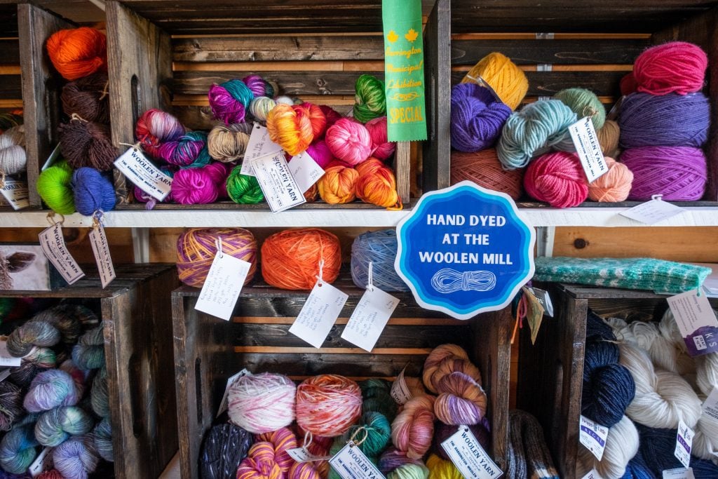 Piles and piles of luscious-looking bright yarn labeled "Hand dyed at the wooden mill."