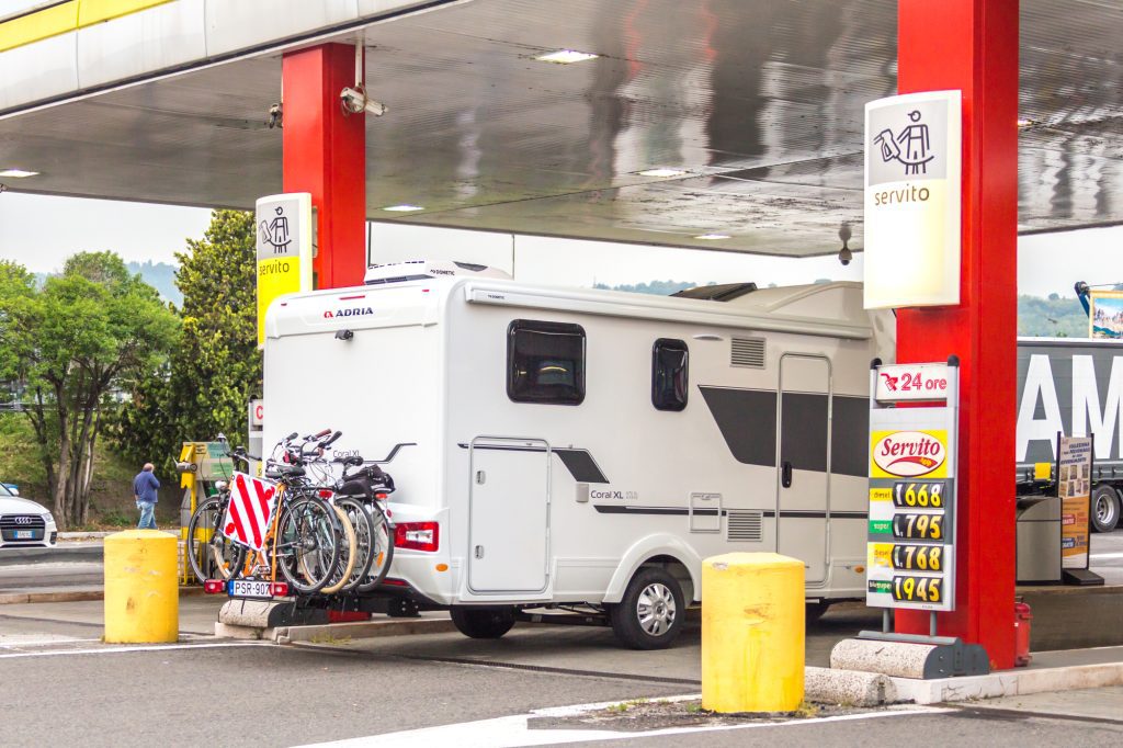 A motorhome pulled up to a gas station in Italy.