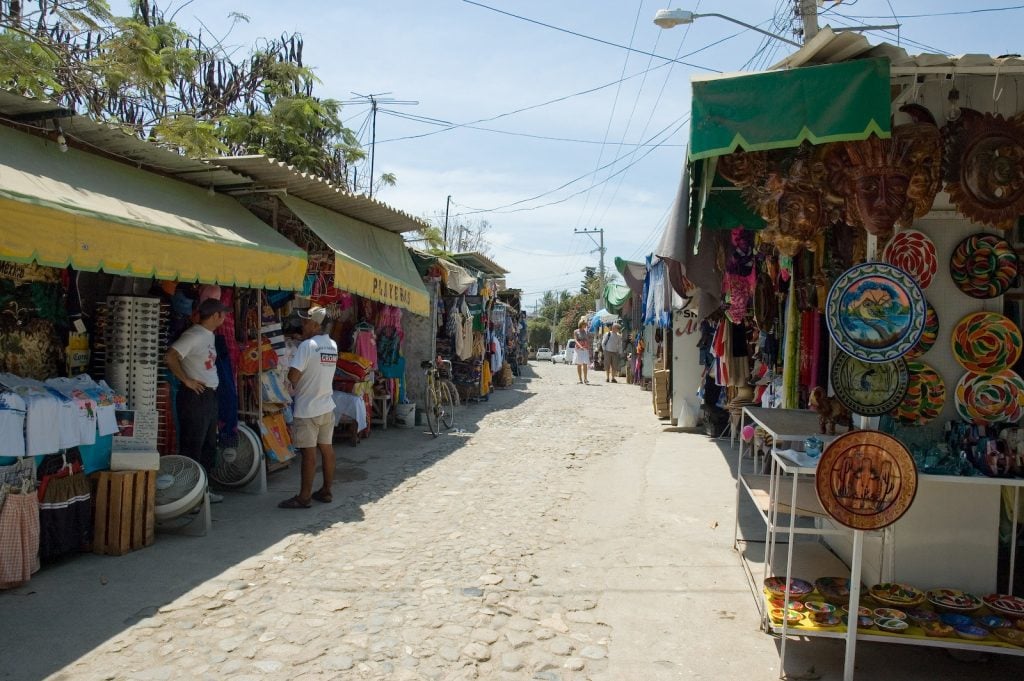 A cobblestone street in Bucerias with street vendors on either side.